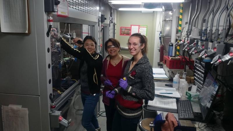 Photograph of Drs. Sunhwa Lee (PDF 2015), Elnaz Latifi (Ph.D. 2017), Maryanne Stones (Ph.D. 2020) setting up a high-pressure hydrogenation reaction in the high-pressure lab.